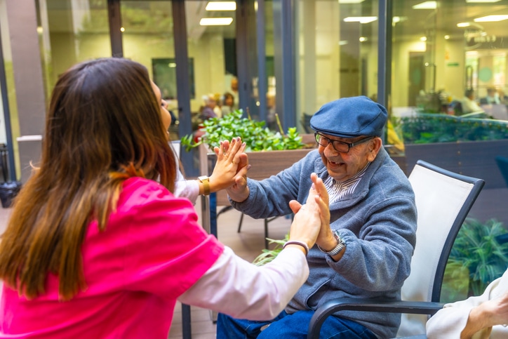 Promyse Home Care caregiver interacting with a happy and grateful senior client which lessons the feelings of isolation and loneliness.