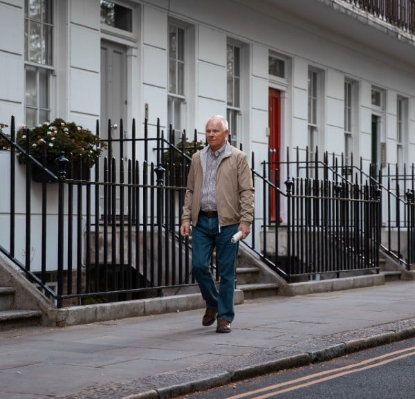 older man wandering down the street